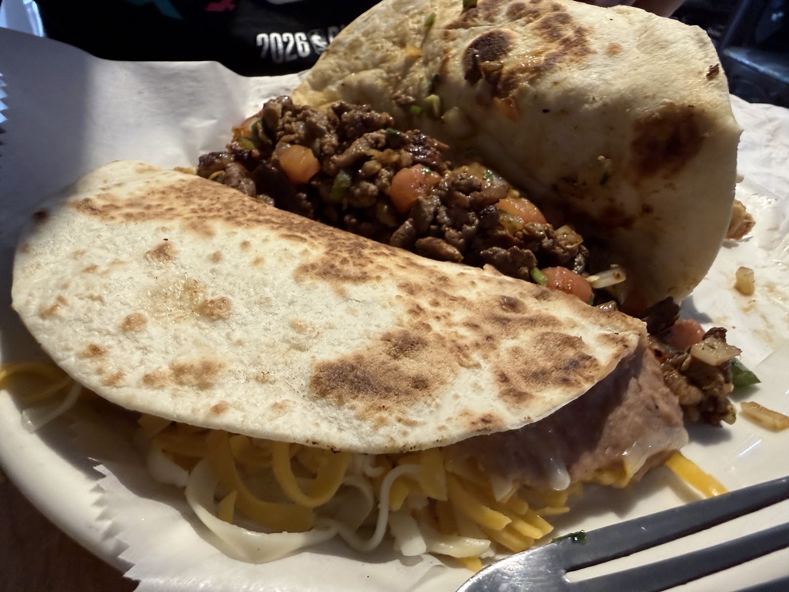 Loaded beef and cheese taco with pico de gallo on a flour tortilla