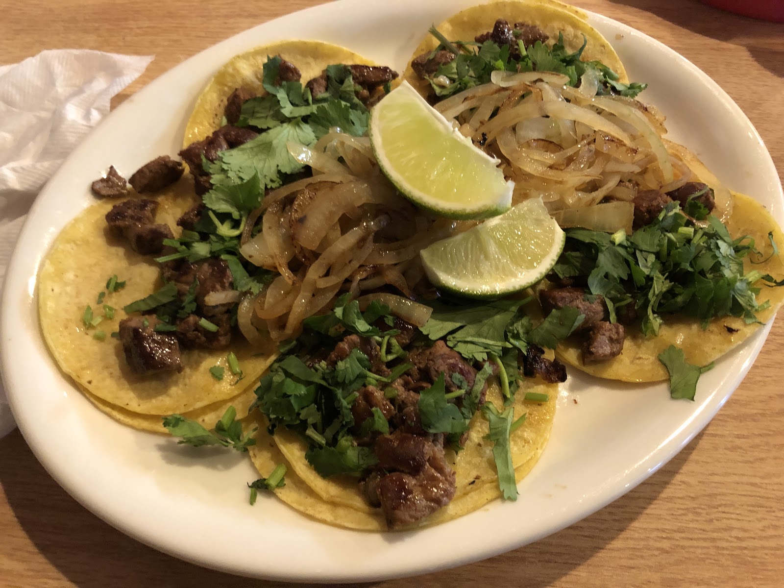 Street tacos topped with grilled onions, cilantro, and fresh lime
